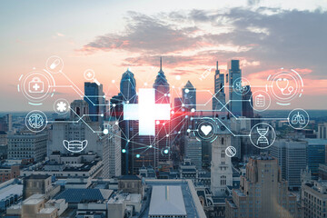 Aerial panoramic cityscape of Philadelphia financial downtown, Pennsylvania, USA. City Hall Clock Tower, sunset. Hologram healthcare digital medicine icons. The concept of treatment from disease