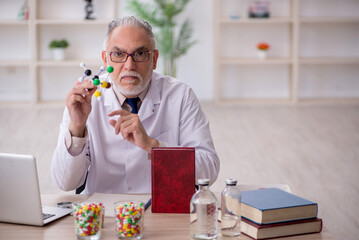 Old male doctor holding molecular model