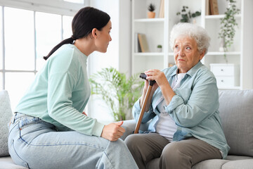 Upset senior woman with her displeased daughter at home