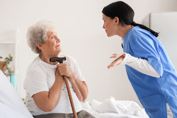 Senior woman scared of angry nurse in bedroom