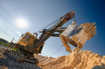 Shovel mining excavator operates in large open chalk quarry
