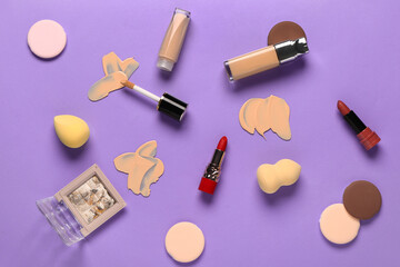 Samples of makeup foundation and decorative cosmetics on purple background