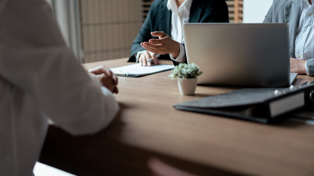 HR manager woman reading resume and asking questions with male candidate while job interviewing