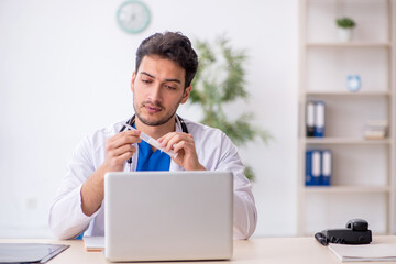 Young male doctor holding syringe at the hospital