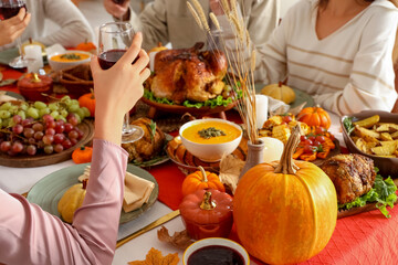Young woman having dinner with her friends at festive table on Thanksgiving Day, closeup