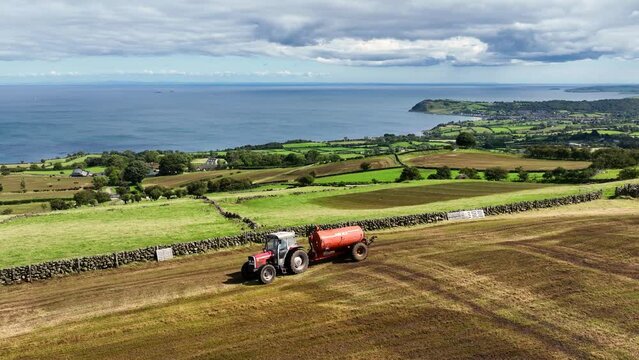 Aerial Video of Massey Ferguson 390T Tractor and Abbey Tanker spreading manure slurry in a field on a farm in UK  09-09-23