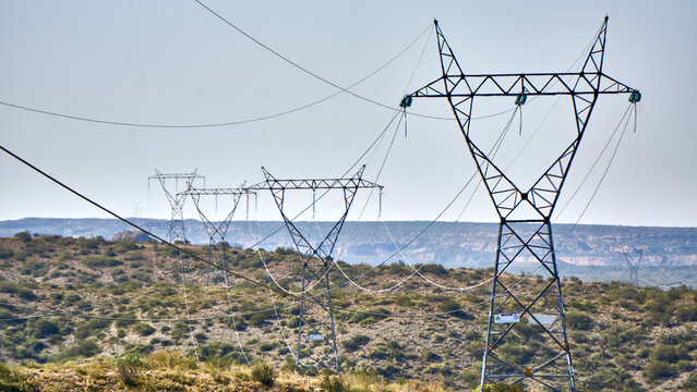Network of High Voltage Power Towers Amidst Majestic Mountains