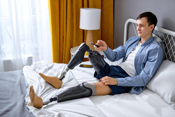 pleasant disabled Caucasian guy with TV controller enjoying movie indoors. Nice young handicapped...