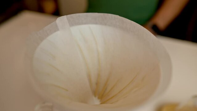 pouring coffee pouder into a filter to tart making filterd amricano coffee
