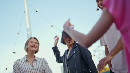 Diverse students dancing together at rooftop party closeup. Carefree youngsters