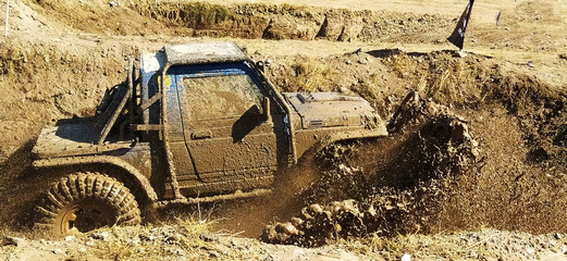
In an extreme race, the off-road vehicle is trying to pass through the muddy track, sports..