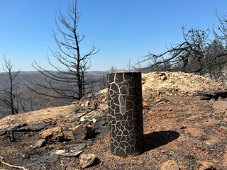 Land after recent wildfire. Dead forest, barren of plants mountains with burned trees trunks. Roads...