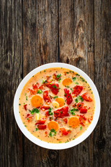 Tomato soup with cream on wooden table
