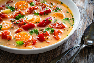 Tomato soup with cream on wooden table
