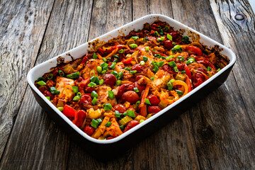 Jambalaya one pot dish - fried chicken breasts with white rice, tomatoes, bell pepper and celery on wooden table
