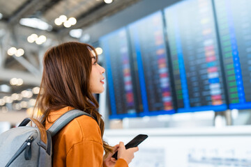 Young asian woman in international airport, using mobile smartphone and checking flight at the...