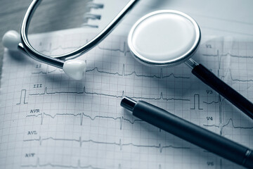 Electrocardiogram (ECG or EKG) with stethoscope. Selective focus. Blue tone image. Medical and healthcare concept.