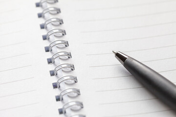 Business concept - Top view of white spiral notebook and pen.