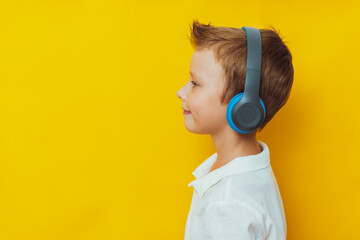 Cute 7 year old boy listening to music on headphones