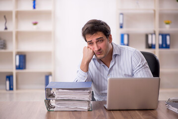 Young male employee and too much work in the office