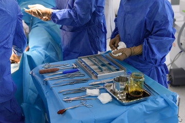 Surgical instruments in the operating room. Orthopedics and traumatology. Scalpel, hooks, chisel, impactor, osteotomes, bone hammer, screwdrivers, forceps. Drill, cutters and extractors on the table. - obrazy, fototapety, plakaty