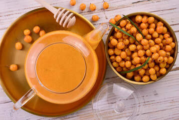 Tea from sea buckthorn berries in a teapot. Flat lei.