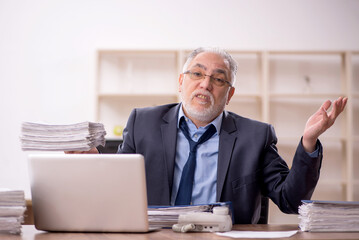 Fototapeta premium Old male employee and too much work in the office