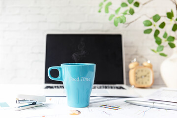 Writing Text Good Time for Good Morning on cup coffee.  Take Care for healthy life office.  Close Coffee cup for relaxation  and break time, laptop background.  Lifestyle Health Concept