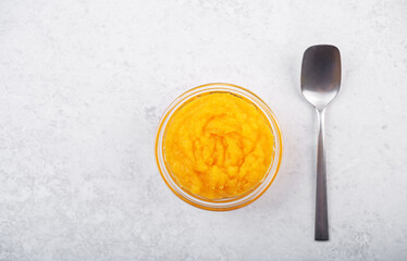 Fresh pumpkin puree in a glass bowl on a white background