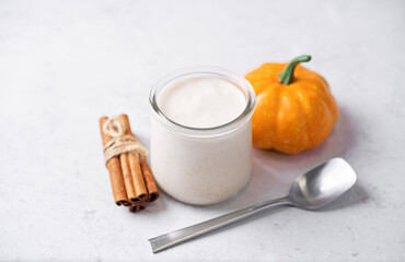 Pumpkin spices coffee creamer in a glass on a white background