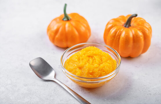 Fresh pumpkin puree in a glass bowl on a white background