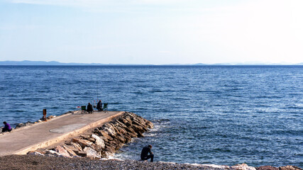 People fishing and resting on the pier.