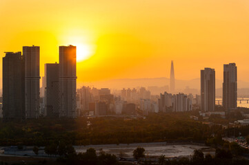 Gold sun risae or sunset of Seoul cityscapes with high rise office buildings and skyscrapers in Seoul city, Republic of Korea in winter blue sky and cloud