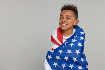 4th of July - Independence Day of USA. Happy boy with American flag on light grey background, space...