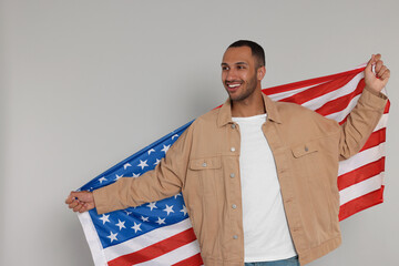 4th of July - Independence Day of USA. Happy man with American flag on light grey background