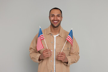 4th of July - Independence Day of USA. Happy man with American flags on light grey background