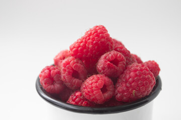 Fresh ripe organic raspberry in a mug