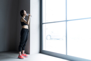 Woman drinking water during sports, fitness and exercise Wide angle