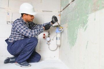 Indian plumber installing water equipment - meter, filter and pressure reducer