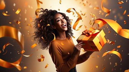 A woman holding a gift box with orange and gold streamers falling down, celebrating - obrazy, fototapety, plakaty