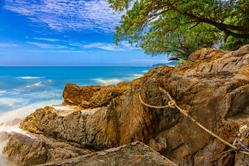Long exposure of waves crushing against rocks on Patong Beach in Phuket Thailand 