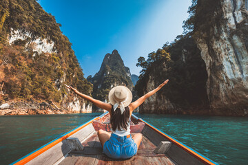 Traveler asian woman relax and travel on Thai longtail boat in Ratchaprapha Dam at Khao Sok National Park Surat Thani Thailand - 655177848