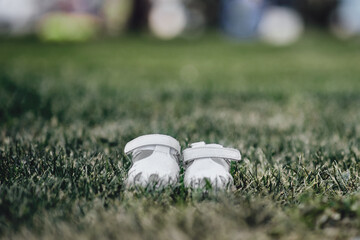 White lost sneakers on the grass. Selective focus and shallow depth of field.