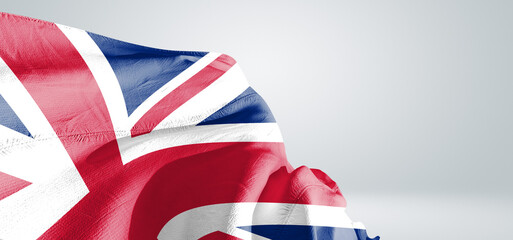United Kingdom national flag cloth fabric waving on beautiful sky Background.