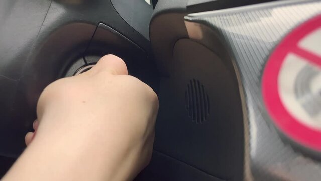 female hands starting a car engine with a key