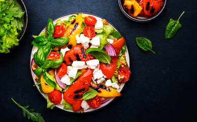 Fresh healthy salad with grilled paprika, feta cheese, walnut, red onion, green basil and mixed...