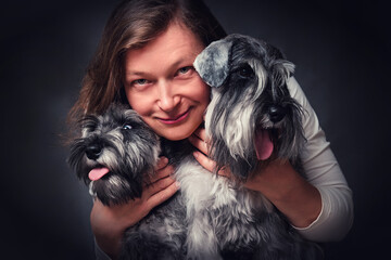 Portrait of a happy woman with two miniature schnauzer puppies
