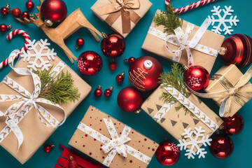 Many different gift boxes with bows and Christmas red balls on a turquoise background top view
