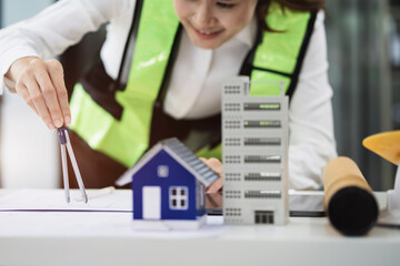Female architect hands making model house. woman architect working in the office.