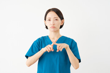 指でばつ印のポーズをする女性の医者　白背景